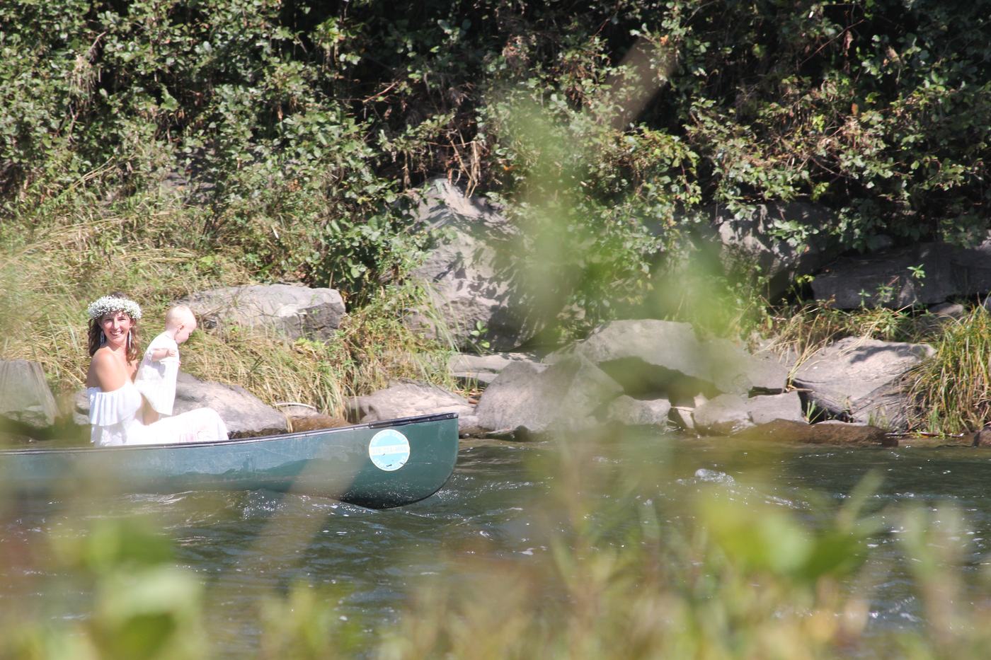 Mother and baby by canoe on the river