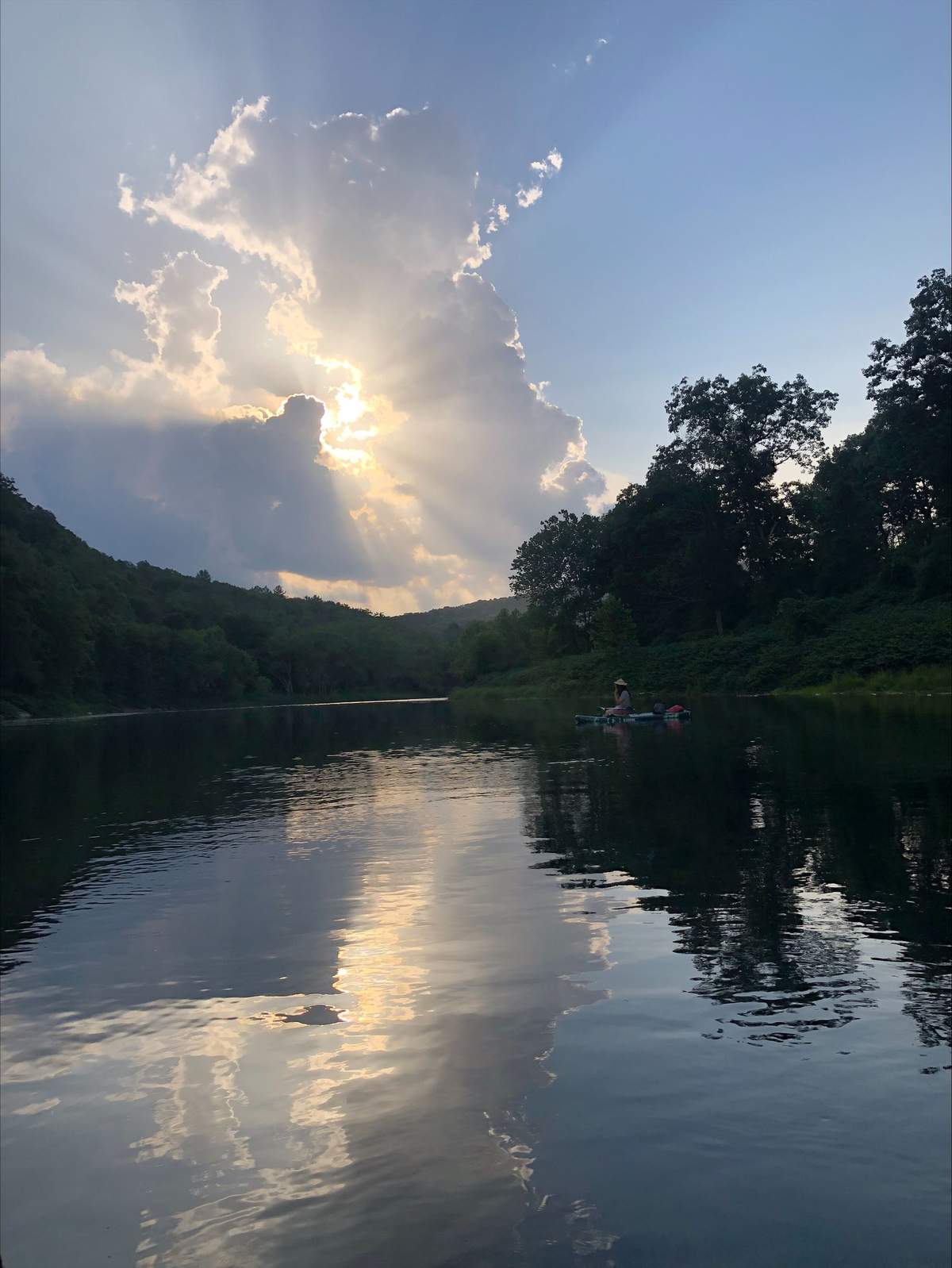 Evening light over the river with a kayaker paddling downstream