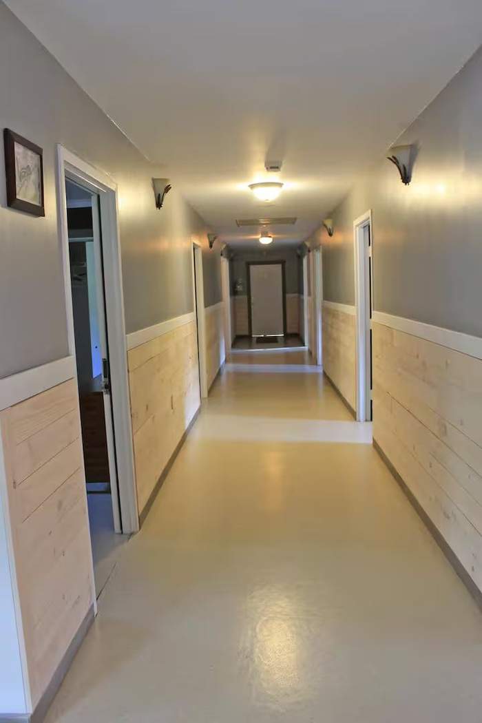 Hallway lined with framed photos leading to bedrooms