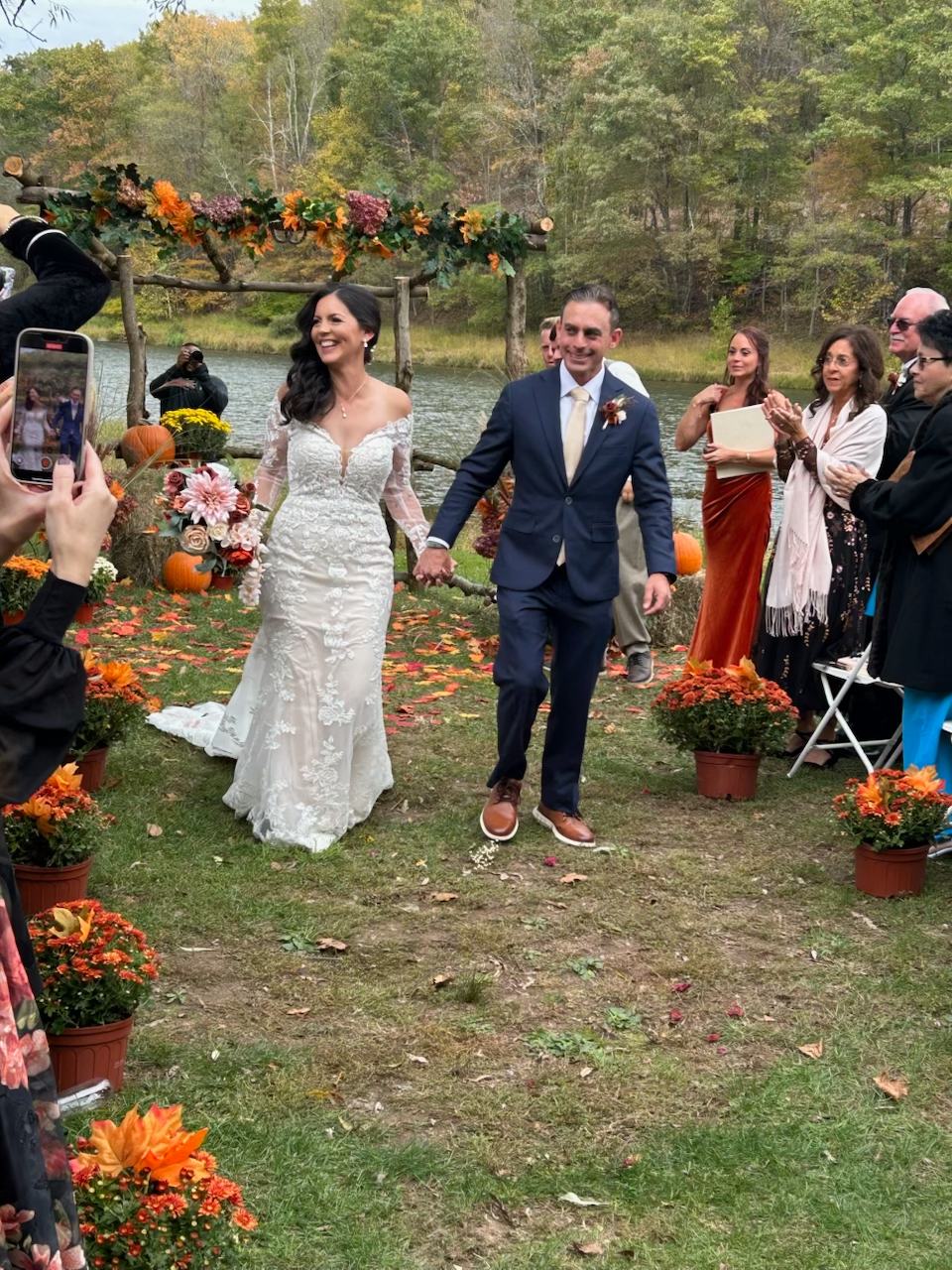 Newlyweds recessional walk through fall leaves